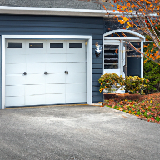 Suburban Acton residential garage door with steel insulated panels and New England landscaping in autumn light.