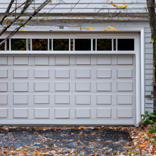 Suburban Acton driveway with a closed residential garage door, visible panels, tracks, and weatherstrip in late autumn.